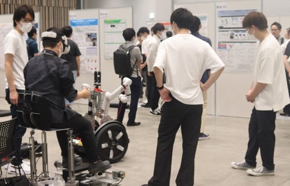 第２８回日本バーチャルリアリティ学会にて参加者にアバターロボットの移動とロボットアームの動作を体験してもらった様子