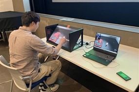 3Dモデル配信によるゴルフトレーナーの遠隔講義を、ミリ波5Gを用いて受講している様子